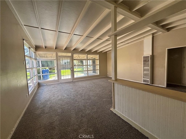 spare room with vaulted ceiling, carpet, and baseboards