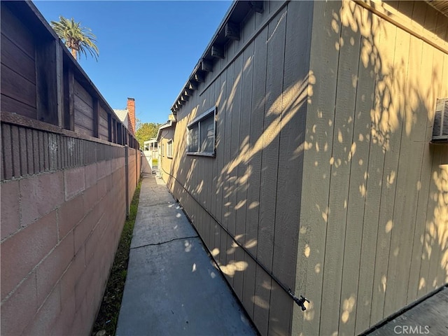 view of side of home featuring fence