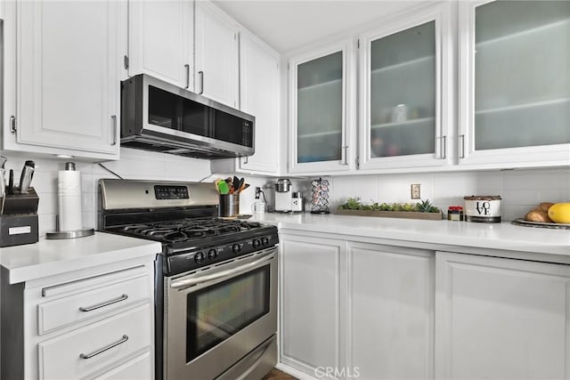 kitchen featuring tasteful backsplash, appliances with stainless steel finishes, white cabinetry, and light countertops