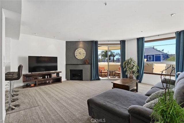 living area with carpet and a large fireplace