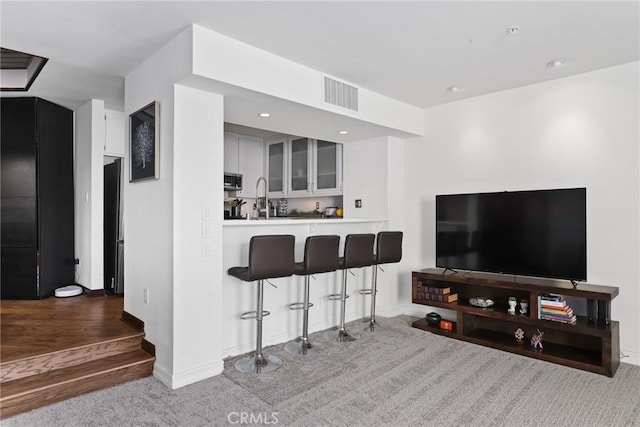 living room with carpet, recessed lighting, visible vents, and baseboards