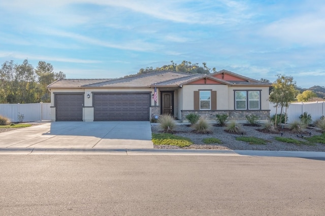 view of front of house with fence, driveway, stucco siding, a garage, and stone siding