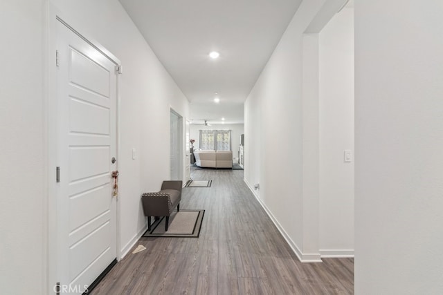 corridor with recessed lighting, baseboards, and wood finished floors