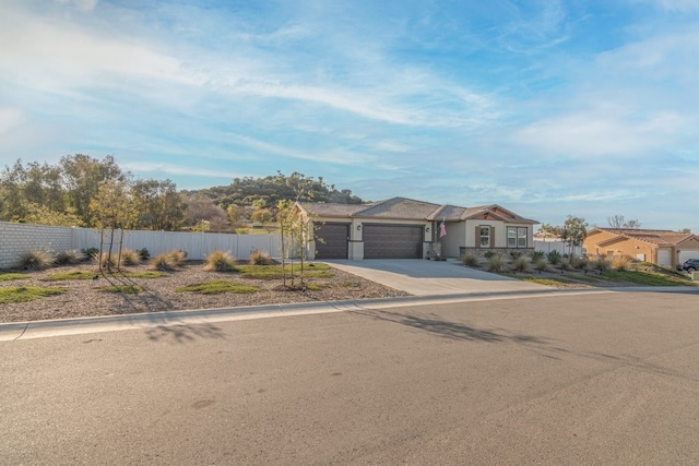 view of front of home with an attached garage, fence, and driveway