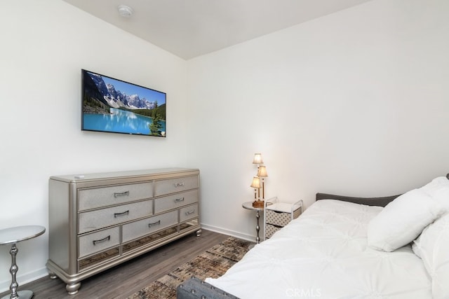 bedroom featuring baseboards and dark wood-style flooring