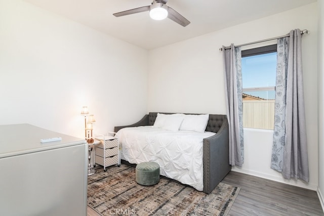 bedroom featuring a ceiling fan, wood finished floors, and baseboards