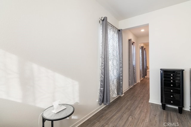 corridor with beverage cooler, baseboards, and wood finished floors