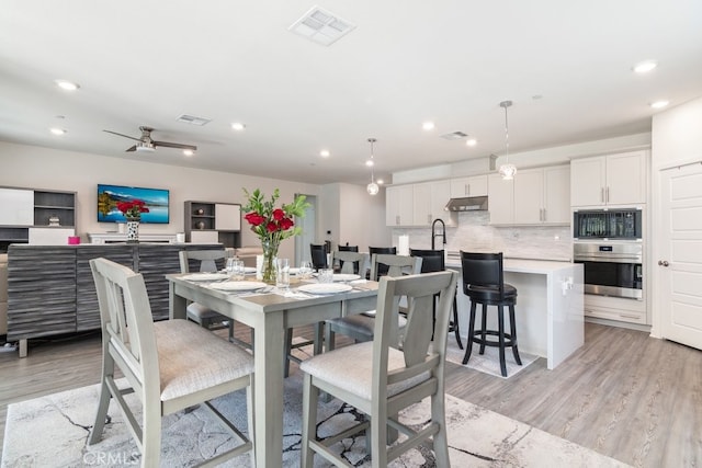 dining room featuring light wood finished floors, visible vents, and recessed lighting