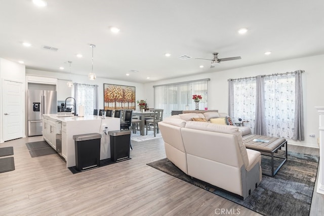 living area featuring recessed lighting, visible vents, and light wood-style flooring