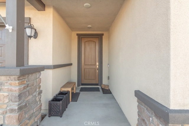 view of exterior entry featuring stucco siding