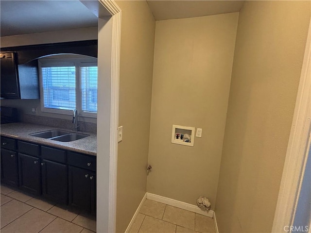 laundry area featuring washer hookup, a sink, light tile patterned flooring, baseboards, and laundry area