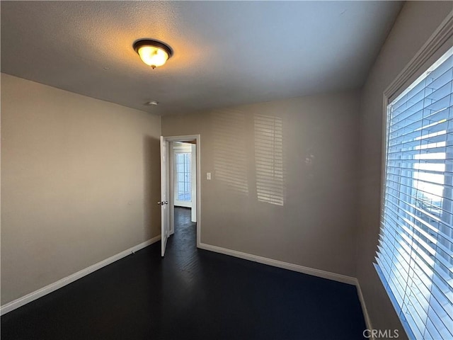 empty room featuring baseboards and a textured ceiling