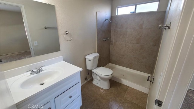 full bath with a tile shower, tile patterned flooring, toilet, and vanity