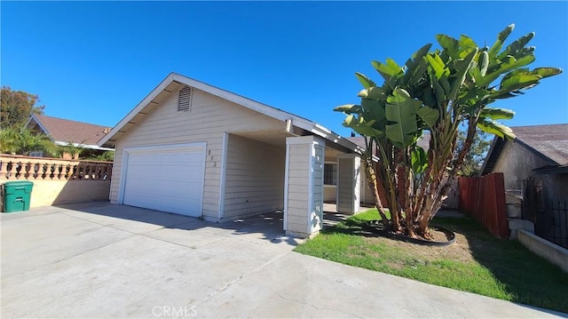 view of front of property featuring a garage, driveway, and fence