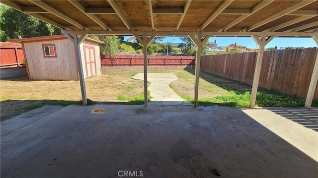 view of patio / terrace featuring a storage unit, an outbuilding, and a fenced backyard