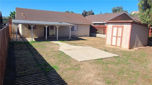 rear view of house featuring a shed, a lawn, a fenced backyard, an outdoor structure, and a patio area