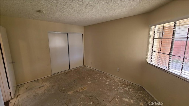 unfurnished bedroom with a closet and a textured ceiling