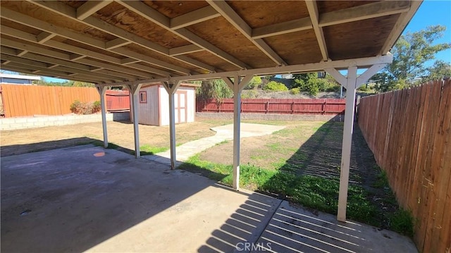 view of patio featuring an outbuilding, a storage shed, and a fenced backyard