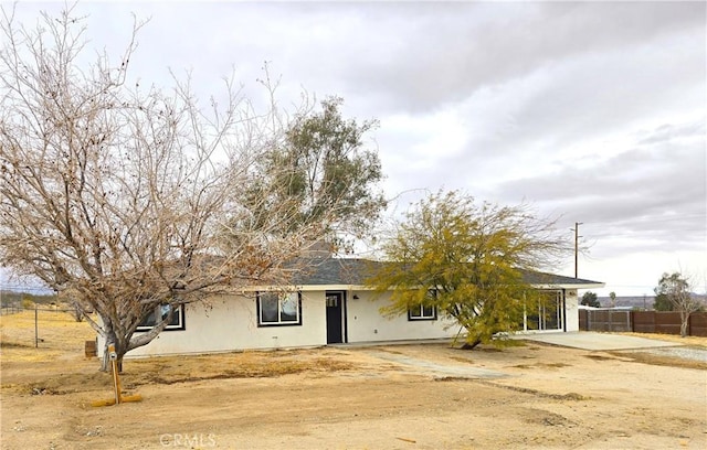 ranch-style house with stucco siding and fence