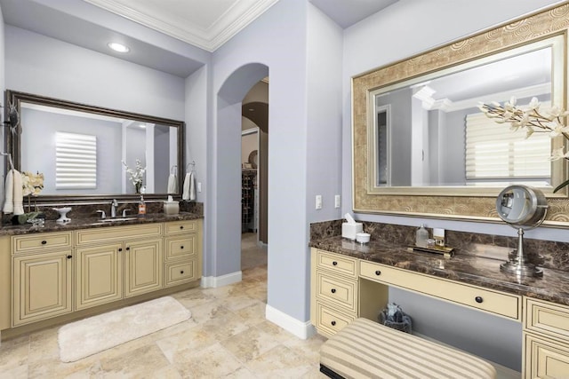 bathroom featuring vanity, baseboards, a wealth of natural light, and ornamental molding