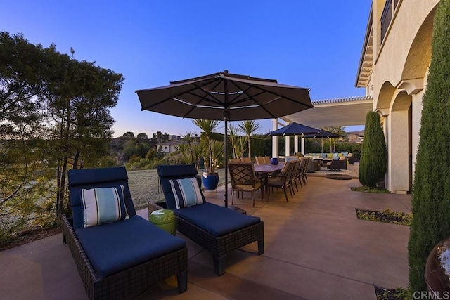 patio terrace at dusk featuring an outdoor living space, outdoor dining area, and a pergola