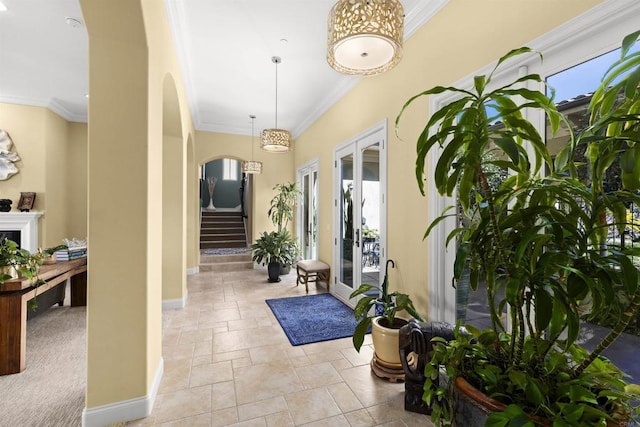 interior space with stairs, arched walkways, baseboards, and ornamental molding