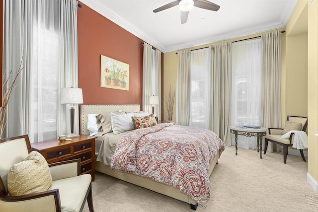 carpeted bedroom with crown molding and a ceiling fan