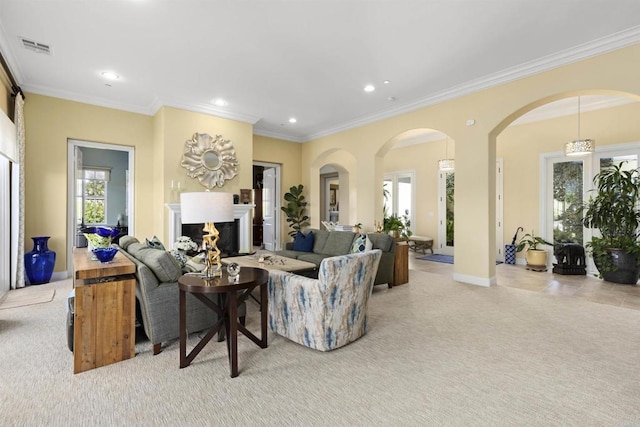 carpeted living room featuring visible vents, recessed lighting, a fireplace, arched walkways, and crown molding