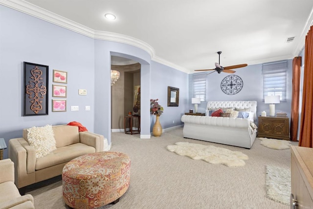 carpeted bedroom with visible vents, ceiling fan with notable chandelier, baseboards, and ornamental molding