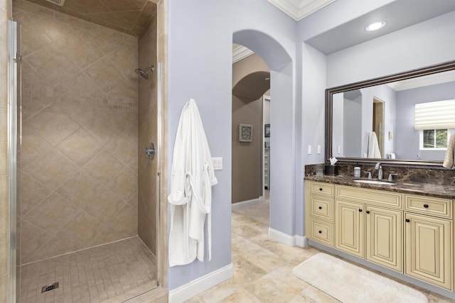 full bathroom with vanity, baseboards, a stall shower, and ornamental molding