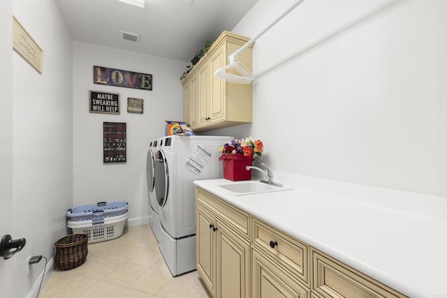 washroom featuring visible vents, baseboards, washer and clothes dryer, cabinet space, and a sink