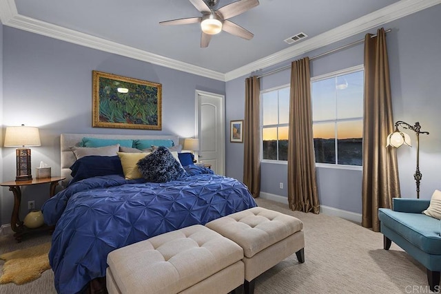 carpeted bedroom with visible vents, baseboards, a ceiling fan, and crown molding