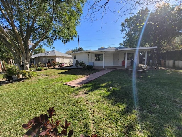 rear view of property featuring a lawn