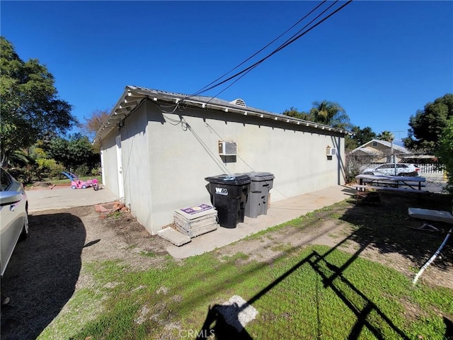 view of property exterior featuring fence and stucco siding