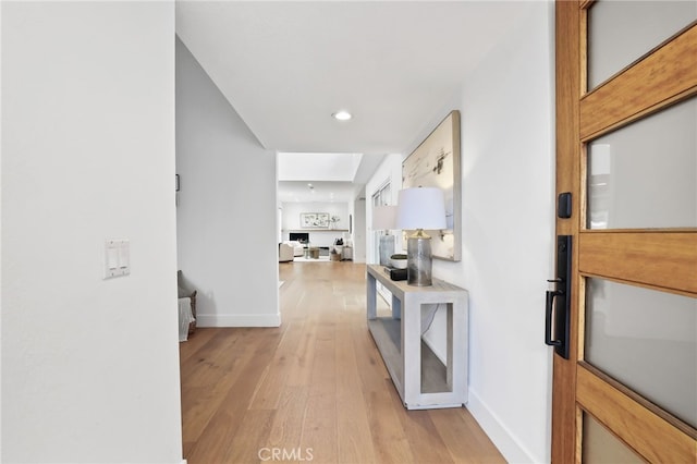 corridor with recessed lighting, light wood-type flooring, and baseboards