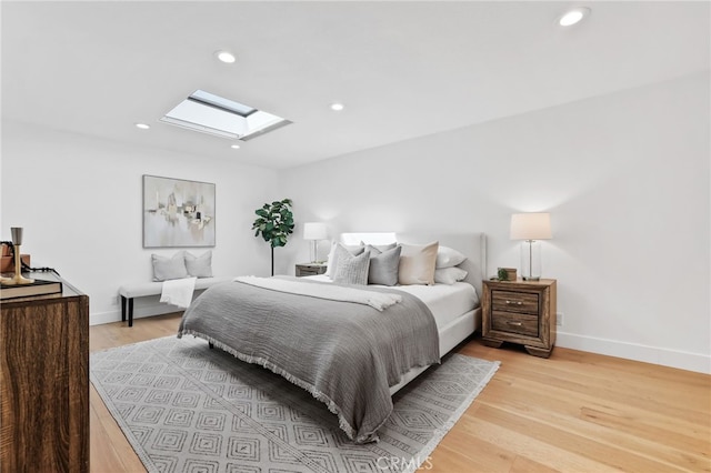 bedroom featuring recessed lighting, light wood-type flooring, baseboards, and a skylight