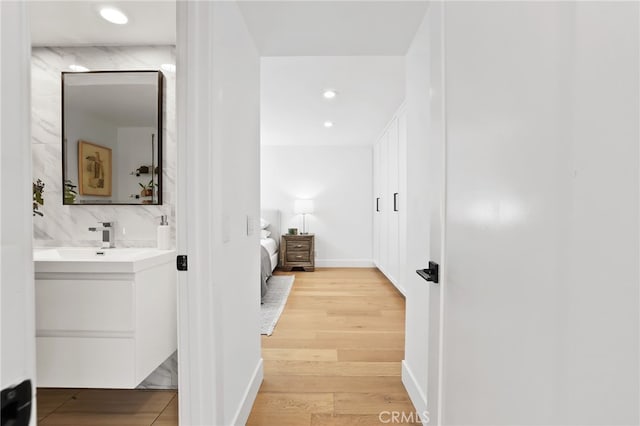 bathroom with ensuite bathroom, wood finished floors, recessed lighting, decorative backsplash, and vanity