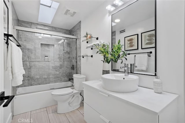 full bath with vanity, visible vents, enclosed tub / shower combo, a skylight, and toilet