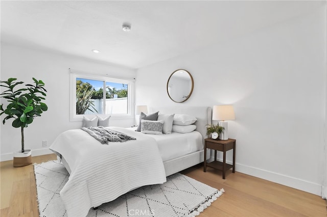 bedroom with recessed lighting, baseboards, and wood finished floors