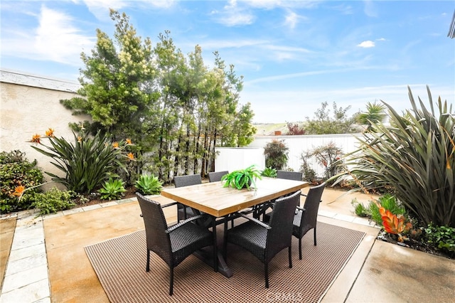 view of patio with outdoor dining area and fence