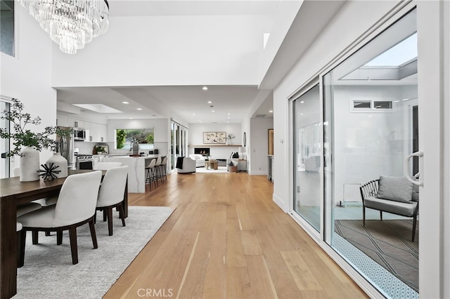 dining room with light wood finished floors, a notable chandelier, and recessed lighting