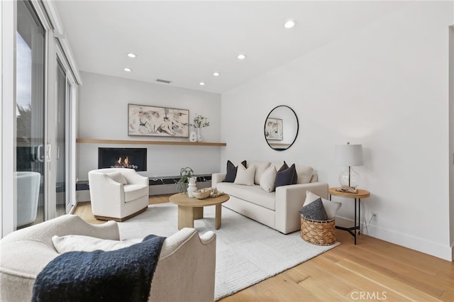 living room with visible vents, recessed lighting, baseboards, and wood finished floors