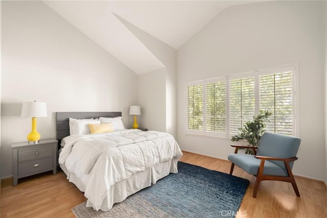 bedroom featuring light wood-style flooring and lofted ceiling