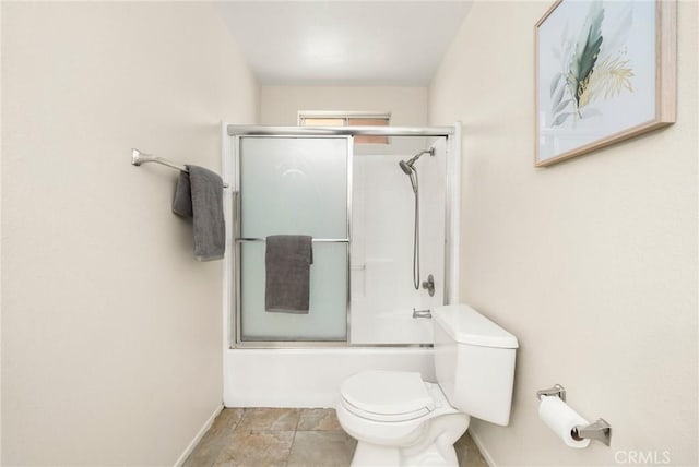 bathroom with enclosed tub / shower combo, toilet, and baseboards