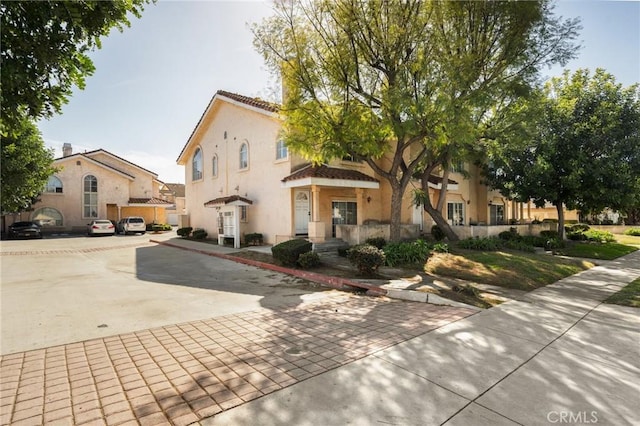 mediterranean / spanish-style home featuring a tile roof and stucco siding