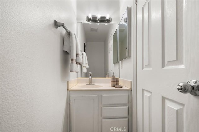 bathroom with vanity and a textured wall