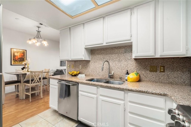 kitchen with a sink, backsplash, dishwasher, white cabinets, and range