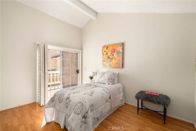 bedroom featuring wood finished floors, access to exterior, and vaulted ceiling with beams