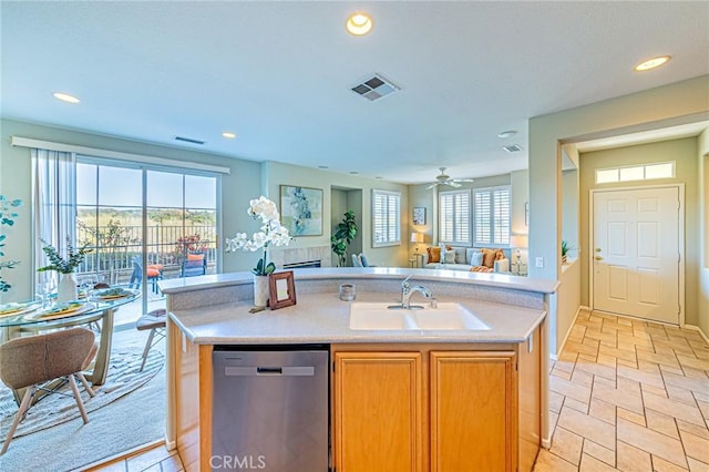 kitchen with visible vents, a sink, stainless steel dishwasher, open floor plan, and light countertops