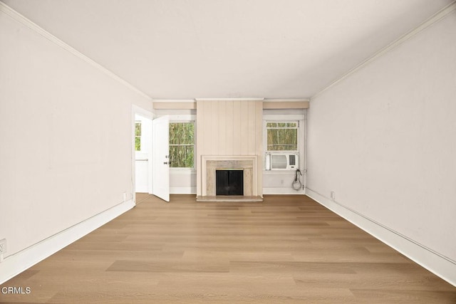 unfurnished living room with a wealth of natural light, crown molding, a high end fireplace, and wood finished floors